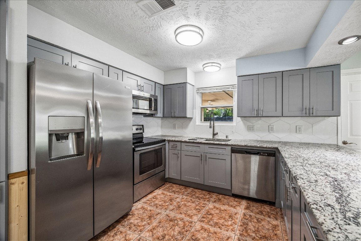 25732 Chestnut Lane Splendora, TX 77372 - Photo 7 of 27 Updated kitchen with granite countertops, new cabinetry, and stainless steel appliances.