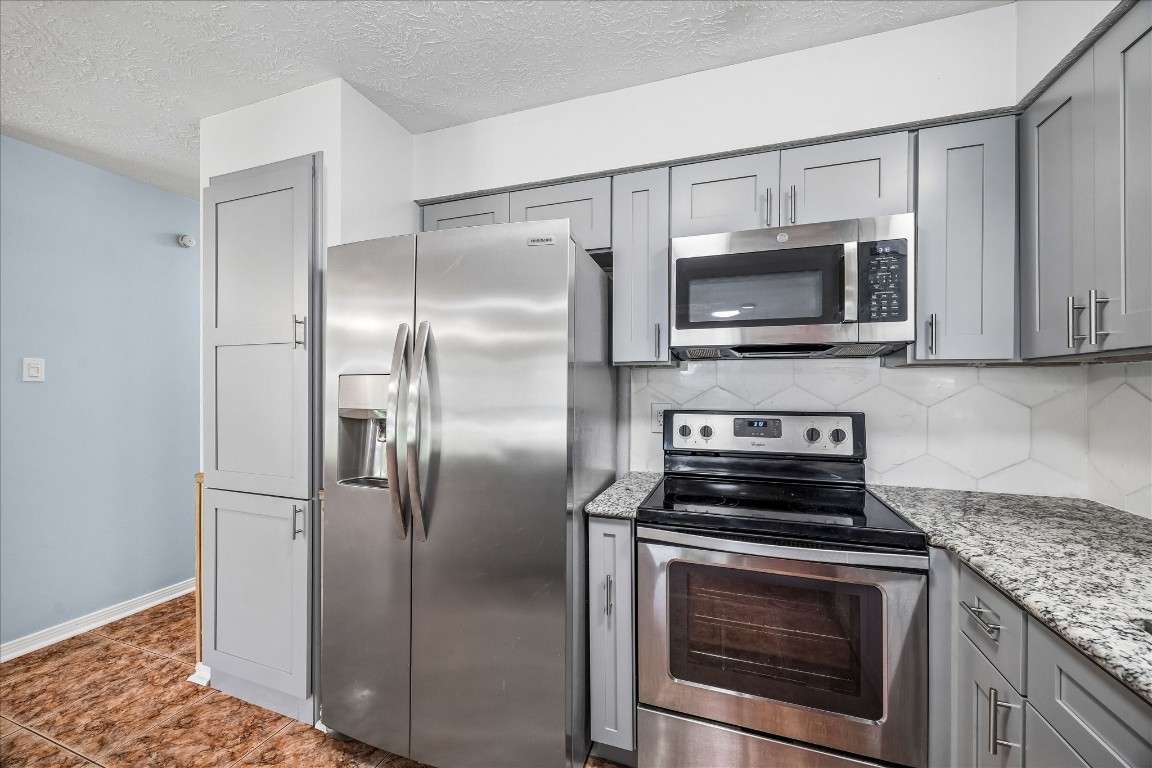 25732 Chestnut Lane Splendora, TX 77372 - Photo 8 of 27 Stainless steel appliances with updated cabinetry, granite countertops, and a pantry for added storage.