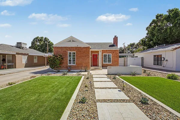 a front view of a house with a garden and yard