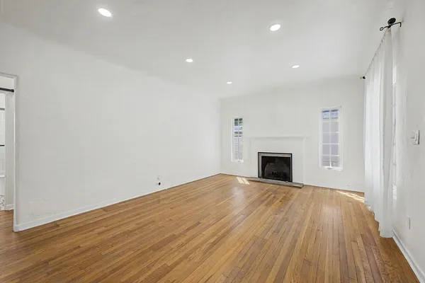 a view of empty room with wooden floor and fireplace