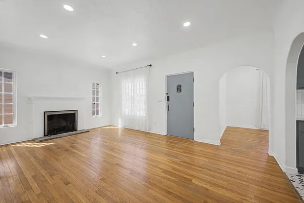 a view of empty room with wooden floor and fireplace