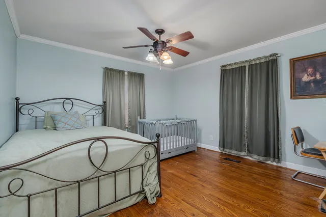 a bedroom with bed and wooden floor