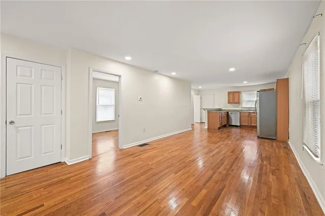 a view of empty room with wooden floor
