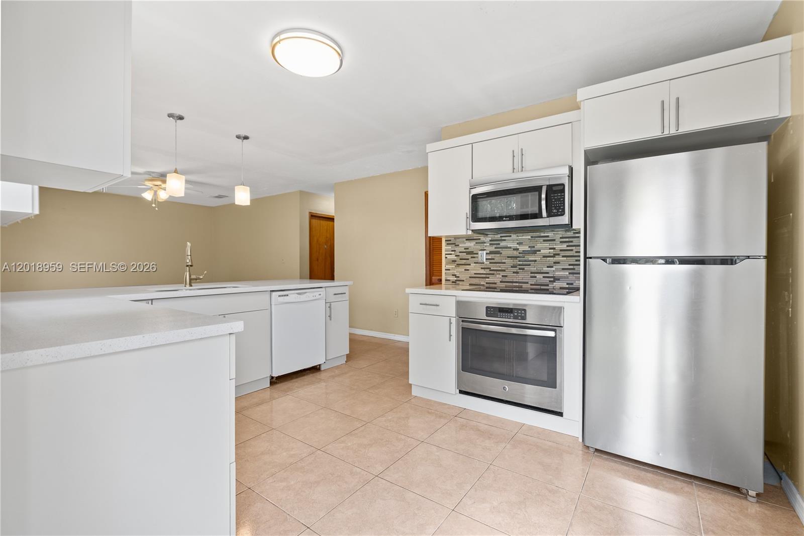 15345 Southwest 63rd Terrace Miami, FL 33193 - Photo 6 of 51 a kitchen with a refrigerator sink and cabinets