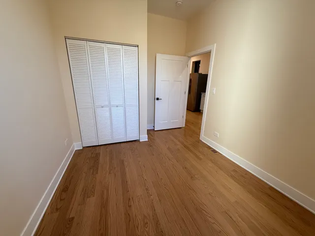 an empty room with wooden floor and closet