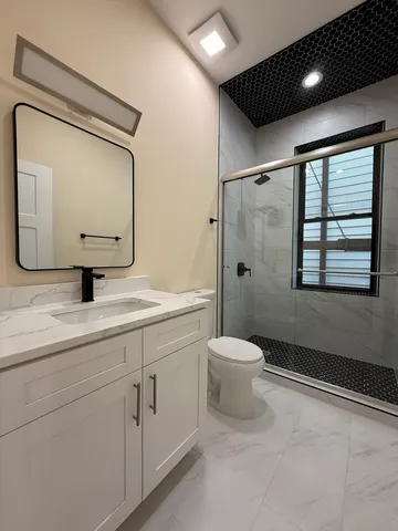 a bathroom with a toilet a sink and mirror