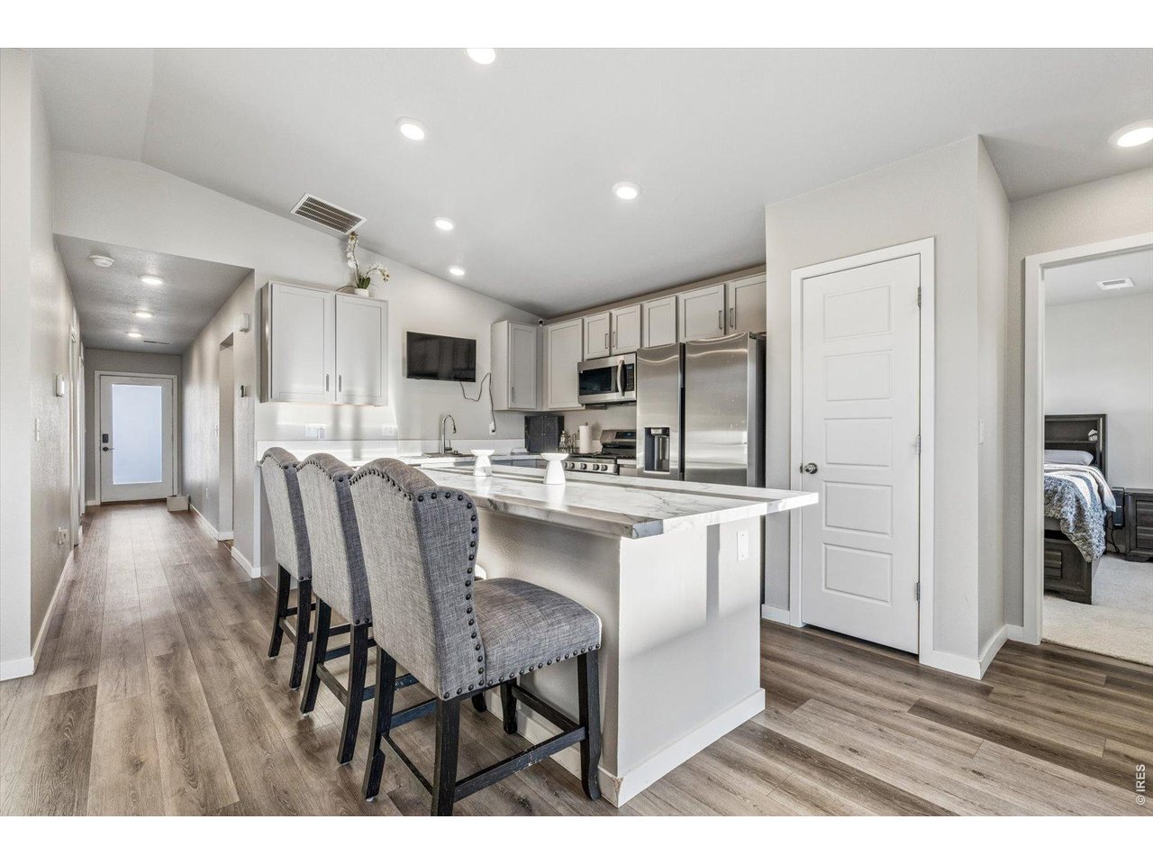 379 Beckwourth Avenue Fort Lupton, CO 80621 - Photo 3 of 26 a kitchen with stainless steel appliances granite countertop a table chairs refrigerator and a sink