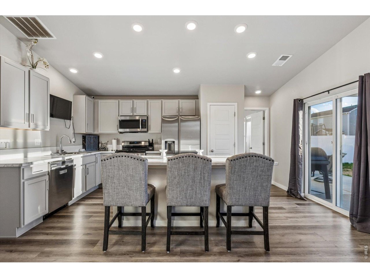 379 Beckwourth Avenue Fort Lupton, CO 80621 - Photo 4 of 26 a kitchen with granite countertop a table chairs microwave and cabinets