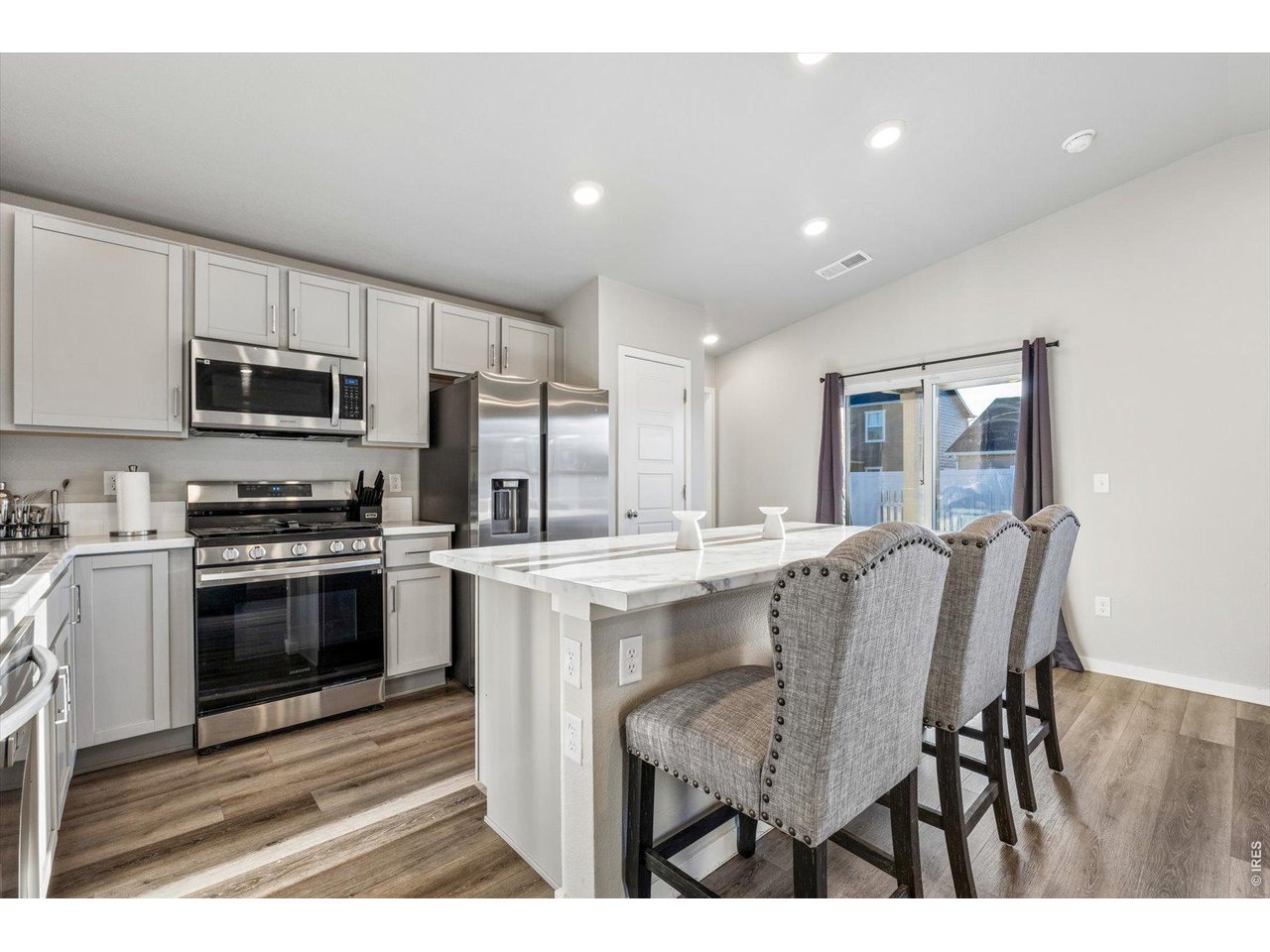 379 Beckwourth Avenue Fort Lupton, CO 80621 - Photo 5 of 26 a kitchen with kitchen island a sink stove and microwave