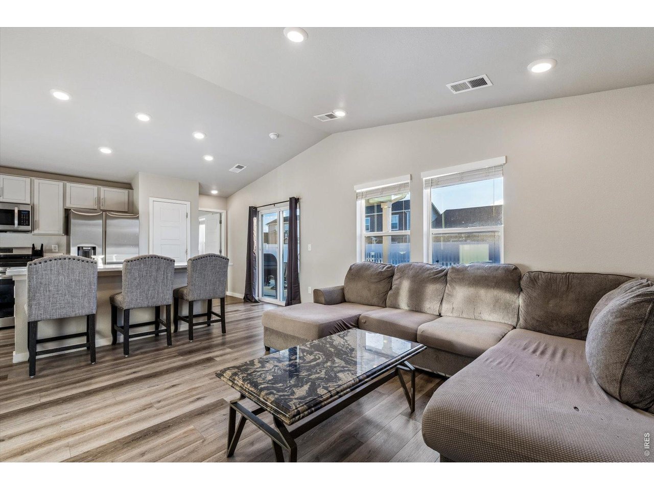 379 Beckwourth Avenue Fort Lupton, CO 80621 - Photo 9 of 26 a living room with furniture and a dining table with kitchen view