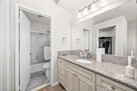 a bathroom with a granite countertop sink a toilet and a large mirror