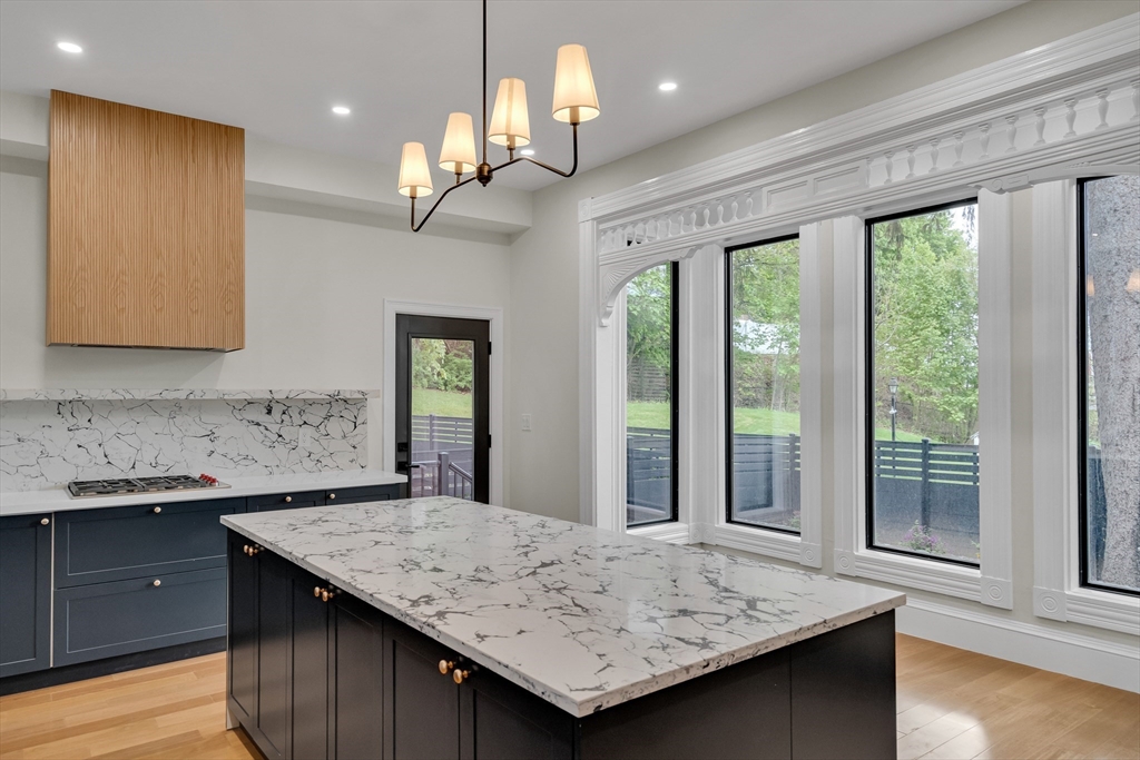 14-16 Summit Street Newton, MA 02458 - Photo 21 of 35 a view of kitchen island a sink wooden floor dining table and chairs