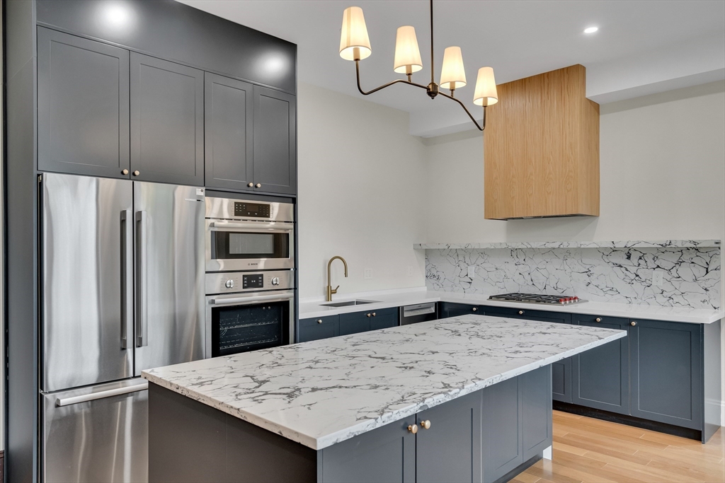 14-16 Summit Street Newton, MA 02458 - Photo 22 of 35 a kitchen with granite countertop a refrigerator a sink and dishwasher