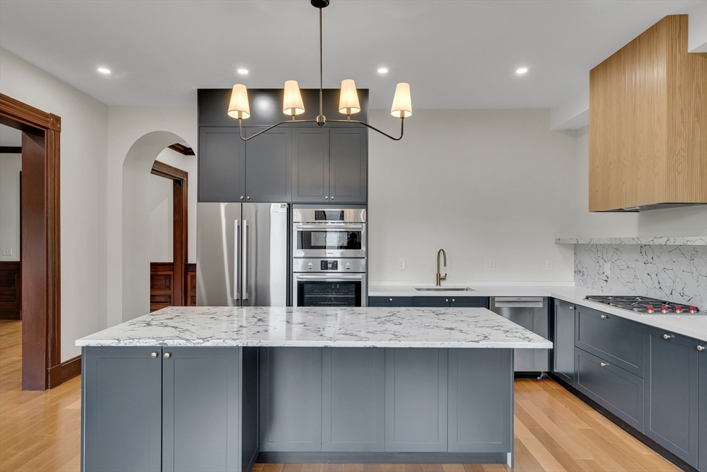 14-16 Summit Street Newton, MA 02458 - Photo 23 of 35 a kitchen with stainless steel appliances granite countertop a sink a stove and a refrigerator
