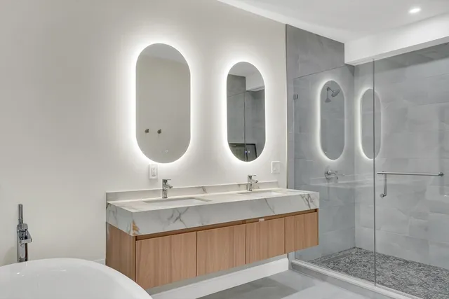 a bathroom with 2 sink bathtub and a mirror