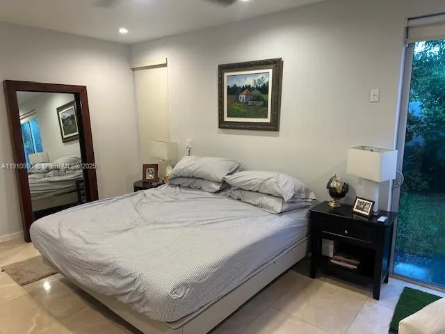 a bedroom with a bed and a view of kitchen