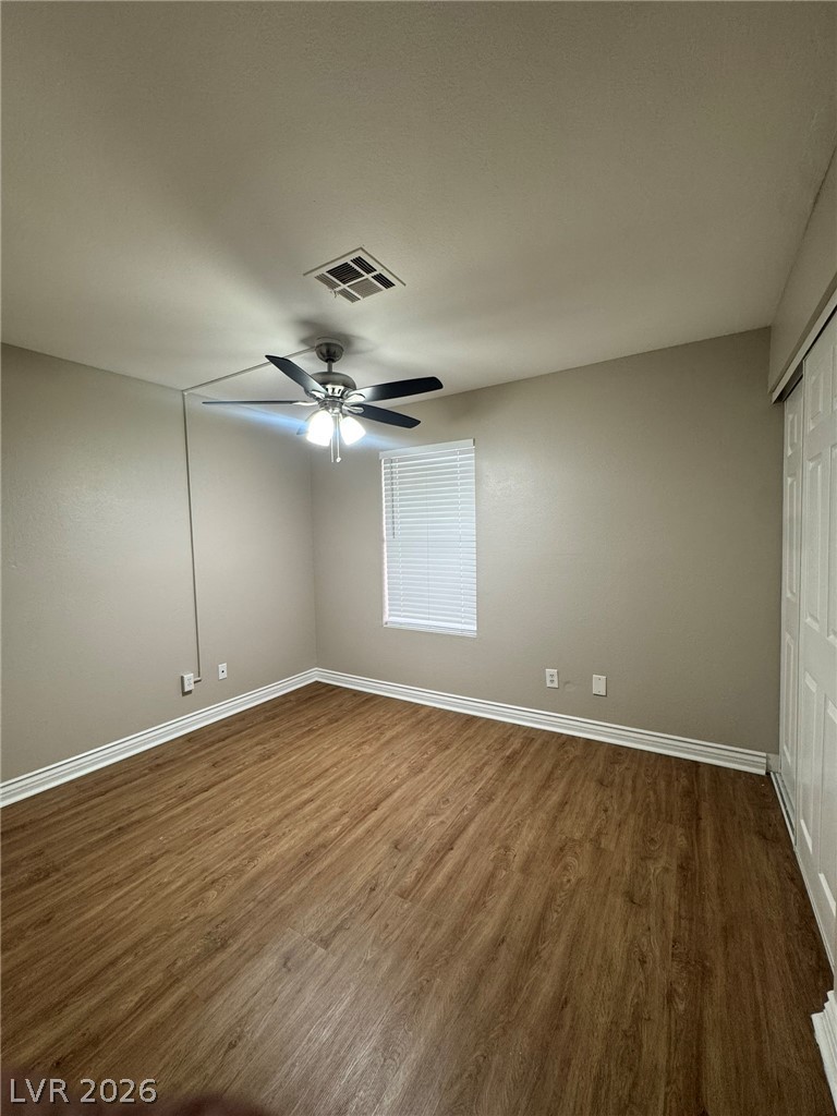 5141 South Lindell Road, Unit 102 Las Vegas, NV 89118 - Photo 13 of 17 Well-lit room features rich wood flooring, a window with blinds, and a practical ceiling fan.