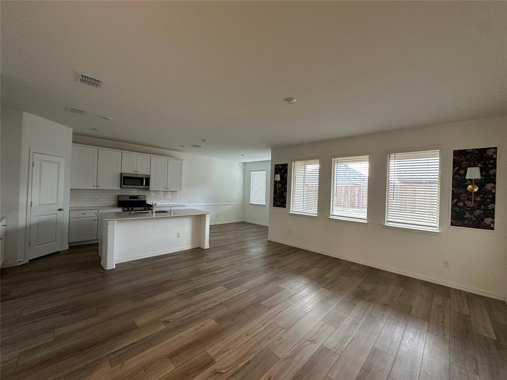 1462 Everett Gdns Way Forney, TX 75126 - Photo 14 of 14 Kitchen featuring open floor plan, white cabinets, a center island with sink, stainless steel appliances, and dark wood finished floors