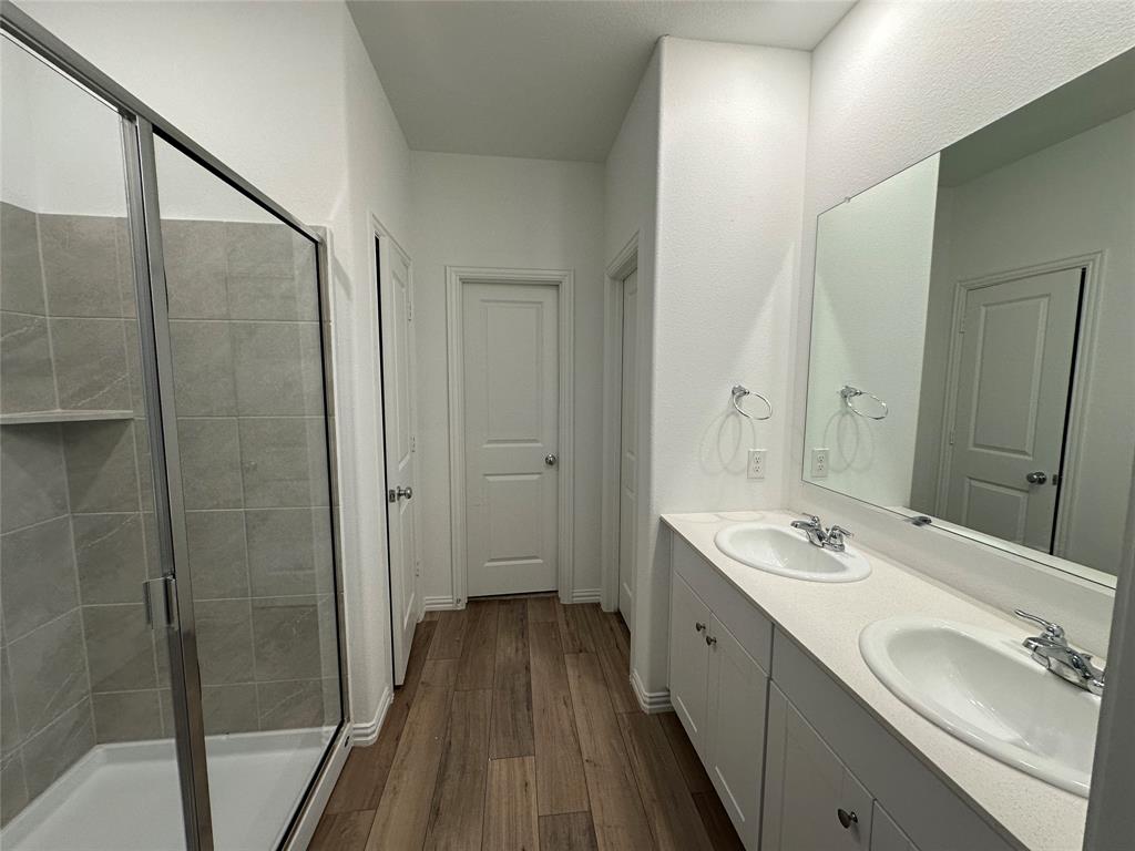 1462 Everett Gdns Way Forney, TX 75126 - Photo 9 of 14 Full bathroom with a shower stall, dark wood-style flooring, and double vanity