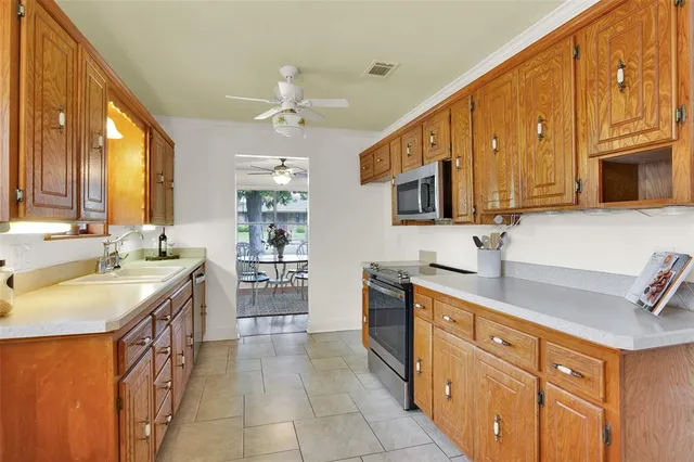 a kitchen with stainless steel appliances granite countertop a sink stove and cabinets
