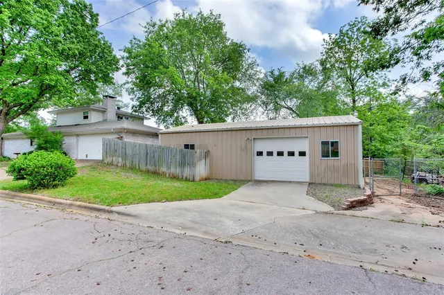 a view of a house with a yard and a large tree