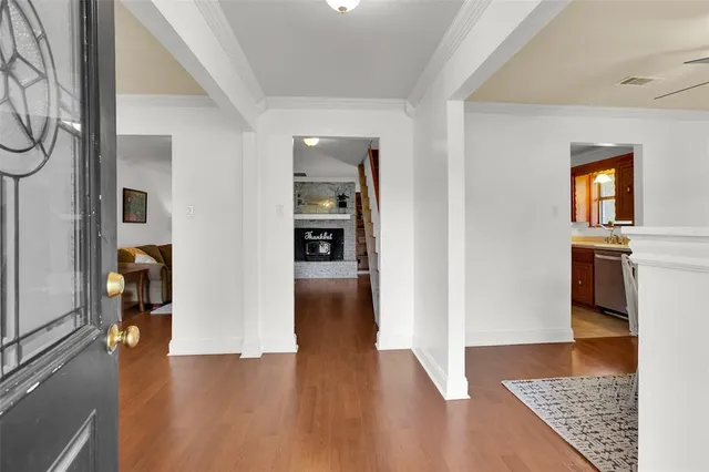 a view of a hallway with wooden floor and a living room