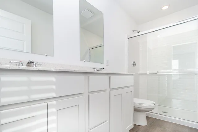 a bathroom with a sink a toilet and shower