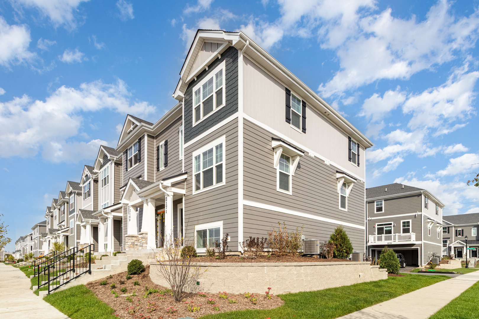 2171 Yellowstone Boulevard, Unit 2171 Mundelein, IL 60060 - Photo 2 of 23 a front view of a residential apartment building with a yard