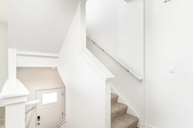 a view of staircase with white walls and a window