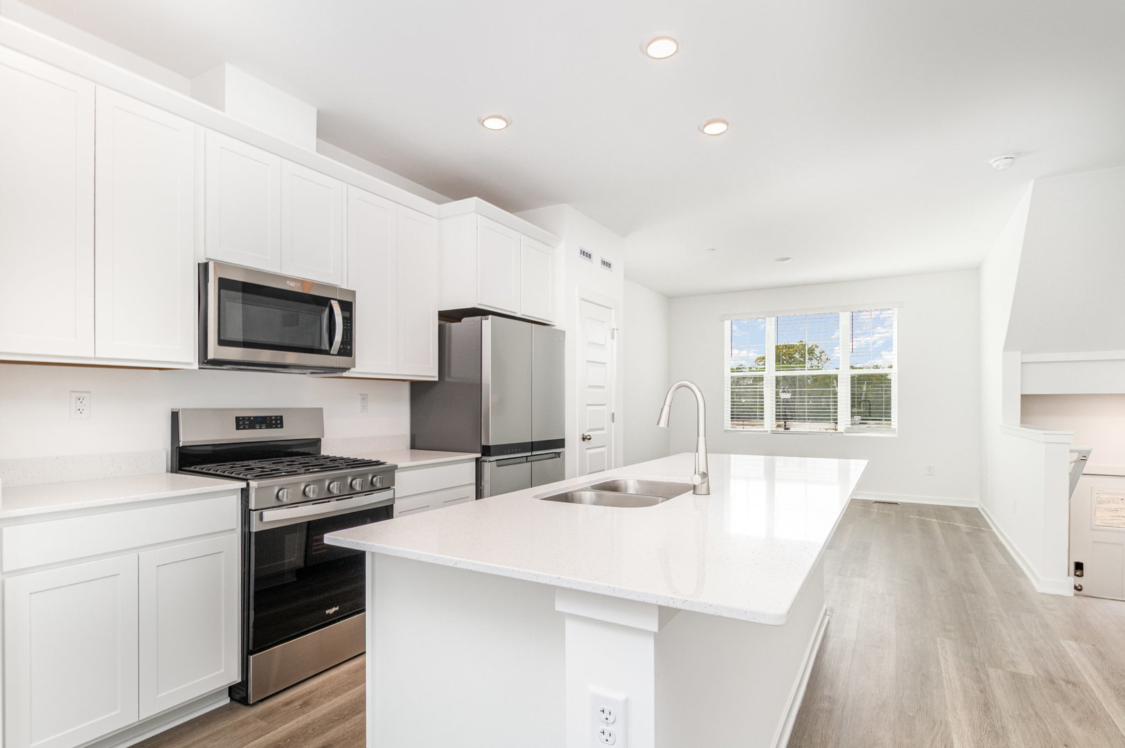 2171 Yellowstone Boulevard, Unit 2171 Mundelein, IL 60060 - Photo 7 of 23 a kitchen with stainless steel appliances a stove a sink a microwave a refrigerator a stove and white cabinets with wooden floor