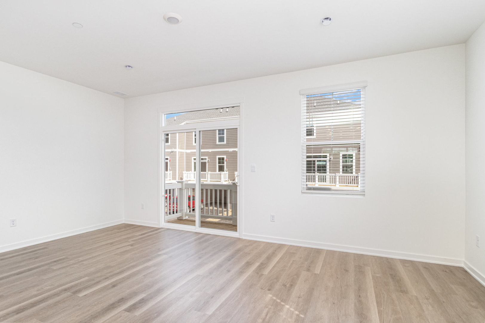 2171 Yellowstone Boulevard, Unit 2171 Mundelein, IL 60060 - Photo 8 of 23 an empty room with wooden floor and windows