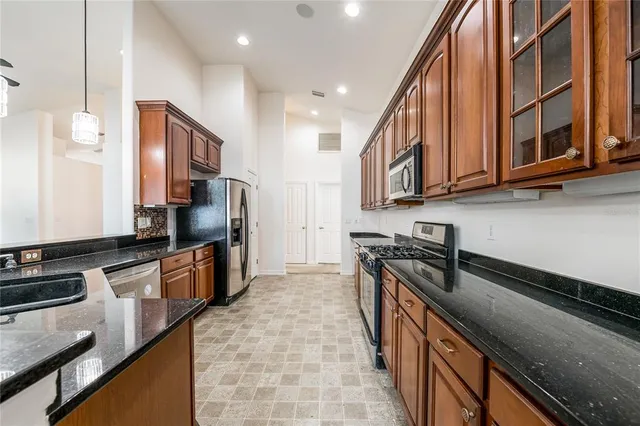 a kitchen with stainless steel appliances granite countertop a stove a sink and a microwave