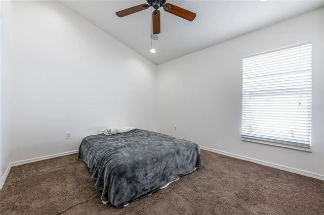 a room with a bed and a chandelier fan