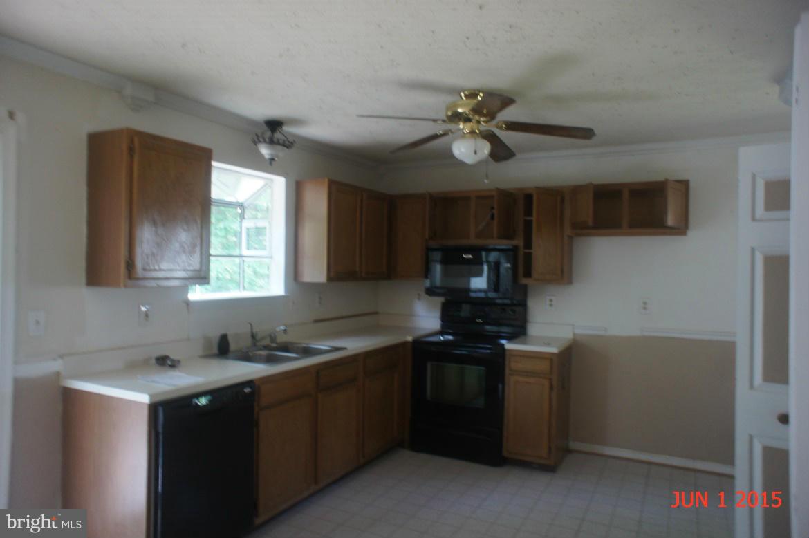 1109 Range Road Lusby, MD 20657 - Photo 5 of 11 a kitchen with stainless steel appliances granite countertop a sink a stove a refrigerator cabinets and a dining table