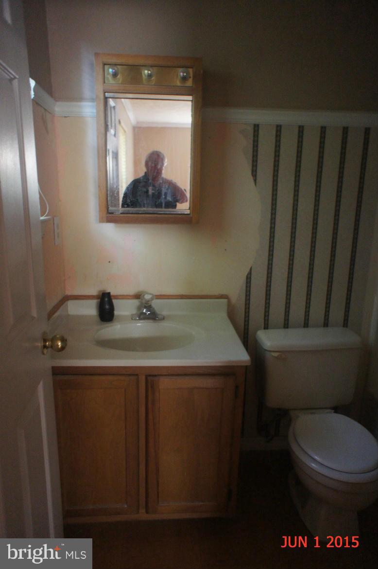 1109 Range Road Lusby, MD 20657 - Photo 8 of 11 a bathroom with a toilet a sink and mirror