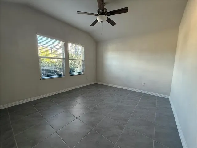 an empty room with windows and fan
