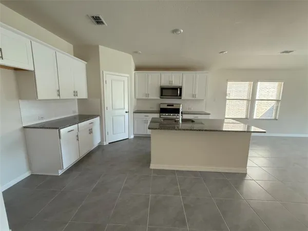 a large kitchen with cabinets and stainless steel appliances