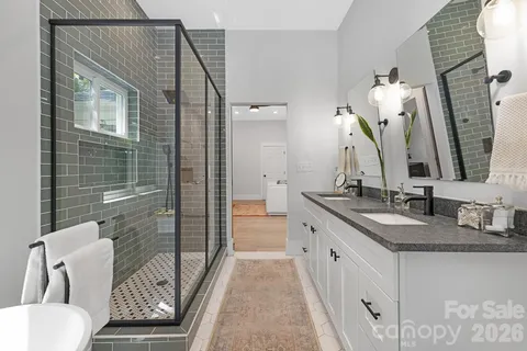 a en suite bathroom with a granite countertop sink and a mirror