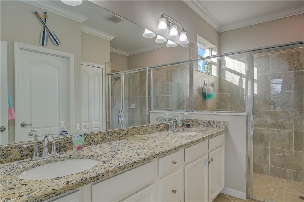 2076 Hamlin Street Naples, FL 34120 - Photo 11 of 24 a bathroom with a granite countertop sink a mirror and a shower