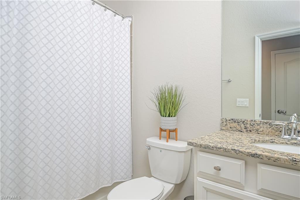 2076 Hamlin Street Naples, FL 34120 - Photo 14 of 24 a bathroom with a granite countertop toilet and a sink