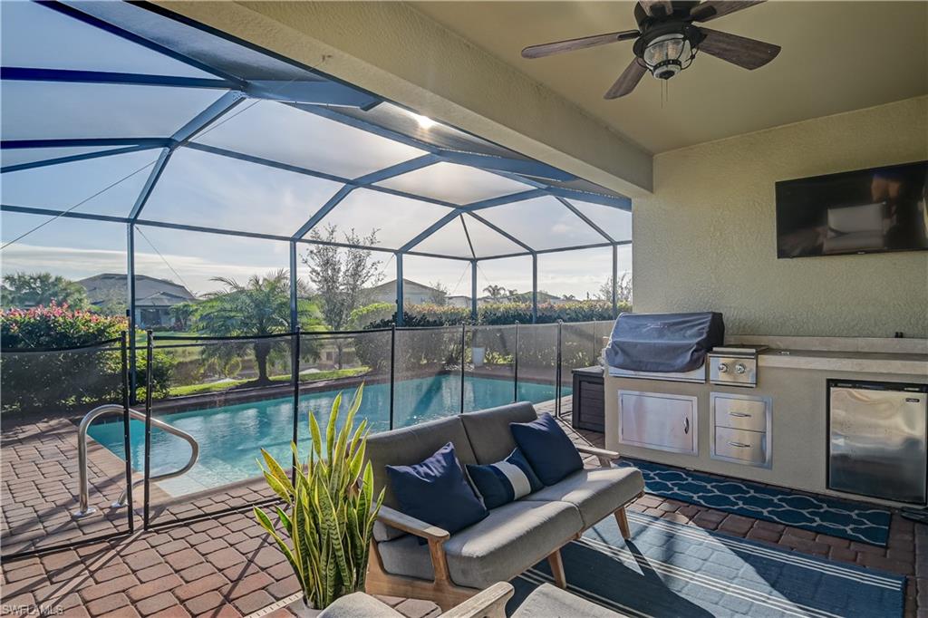 2076 Hamlin Street Naples, FL 34120 - Photo 19 of 24 a living room with furniture a flat screen tv and a floor to ceiling window