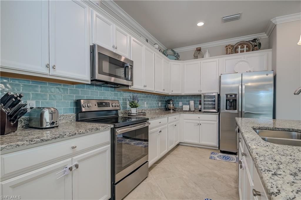 2076 Hamlin Street Naples, FL 34120 - Photo 7 of 24 a kitchen with granite countertop stainless steel appliances and white cabinets