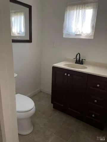 a bathroom with a toilet a sink and mirror