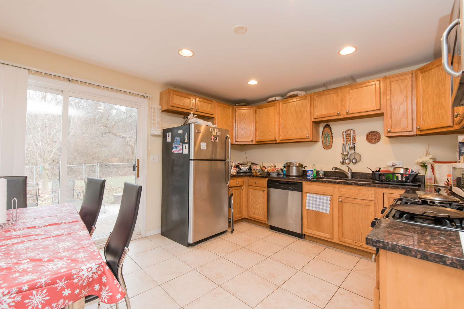 227 Rivers View Drive Carpentersville, IL 60110 - Photo 8 of 24 a kitchen with granite countertop a refrigerator a sink dishwasher a stove top oven a dining table and chairs with wooden floor