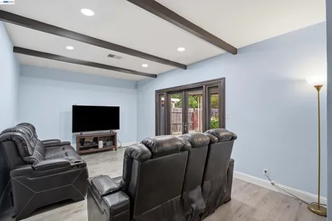 a living room with furniture a flat screen tv and a window