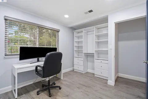 a view of a workspace with furniture and a window