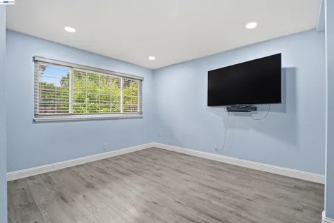 a livingroom with wooden floor and a flat screen tv