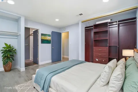 a bedroom with a bed and a potted plant
