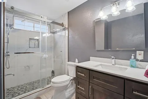 a bathroom with a sink a toilet and shower