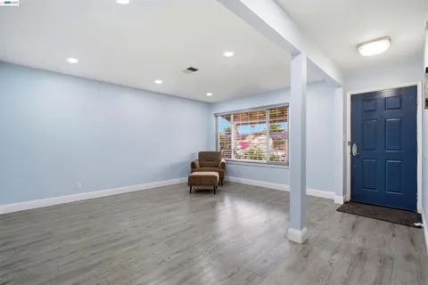 an empty room with wooden floor and window